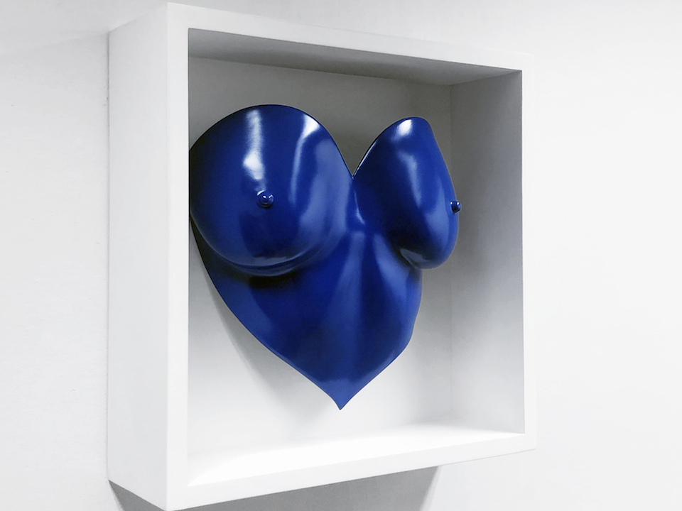 blue painted heart shaped breast cast in a white wooden frame